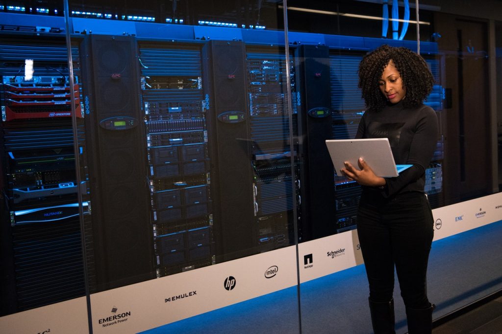 A data expert utilizing a laptop in a data center environment, symbolizing our expertise in comprehensive data warehouse solutions