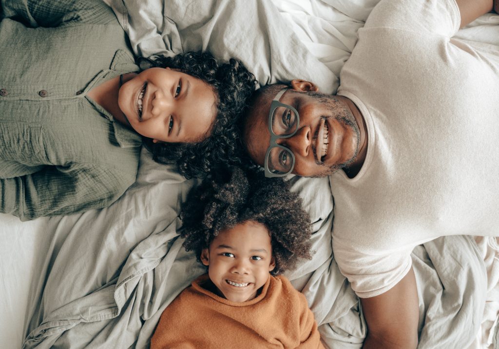Cozy Moments: Black Family Resting Comfortably on Bed